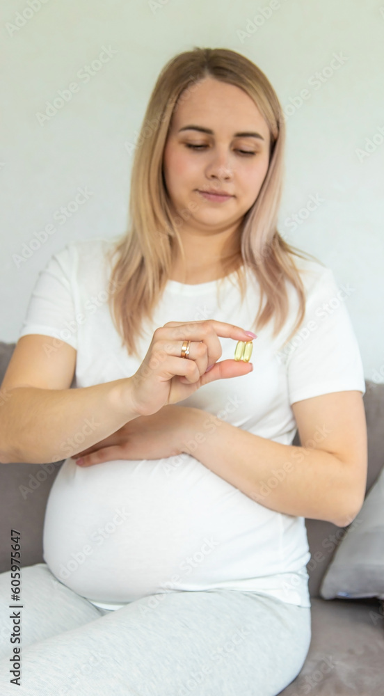 Pregnant woman drinks omega three. Selective focus. Pregnant woman drinks omega three. Selective focus.