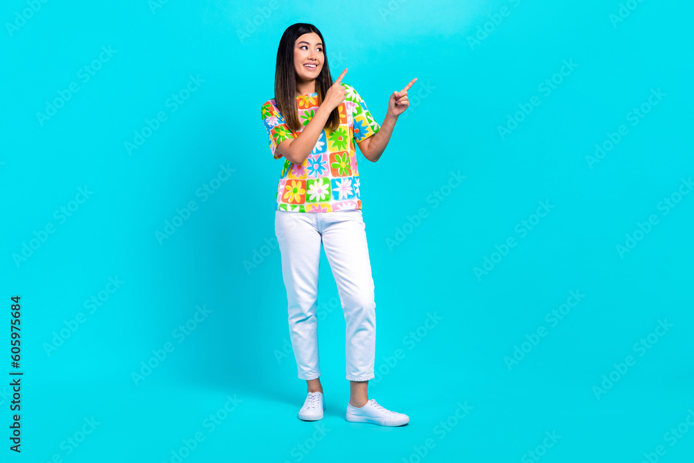 Full length photo of pretty dreamy woman dressed flower print t-shirt showing two fingers looking empty space isolated teal color background Full length photo of pretty dreamy woman dressed flower print t-shirt showing two fingers looking empty space isolated teal color background