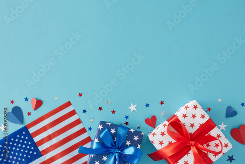 4th of July gift theme concept. Top view flat lay of gift boxes with bows, american flag, red blue hearts and stars confetti on light blue background with empty area for text