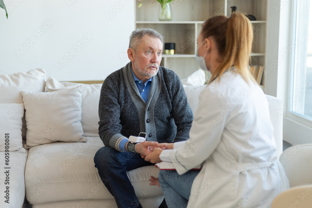 Obraz premium Female doctor senior man taking his blood pressure in doctor office or at home. Old man patient and doctor have consultation in hospital room. Medicine healthcare medical checkup. Visit to doctor