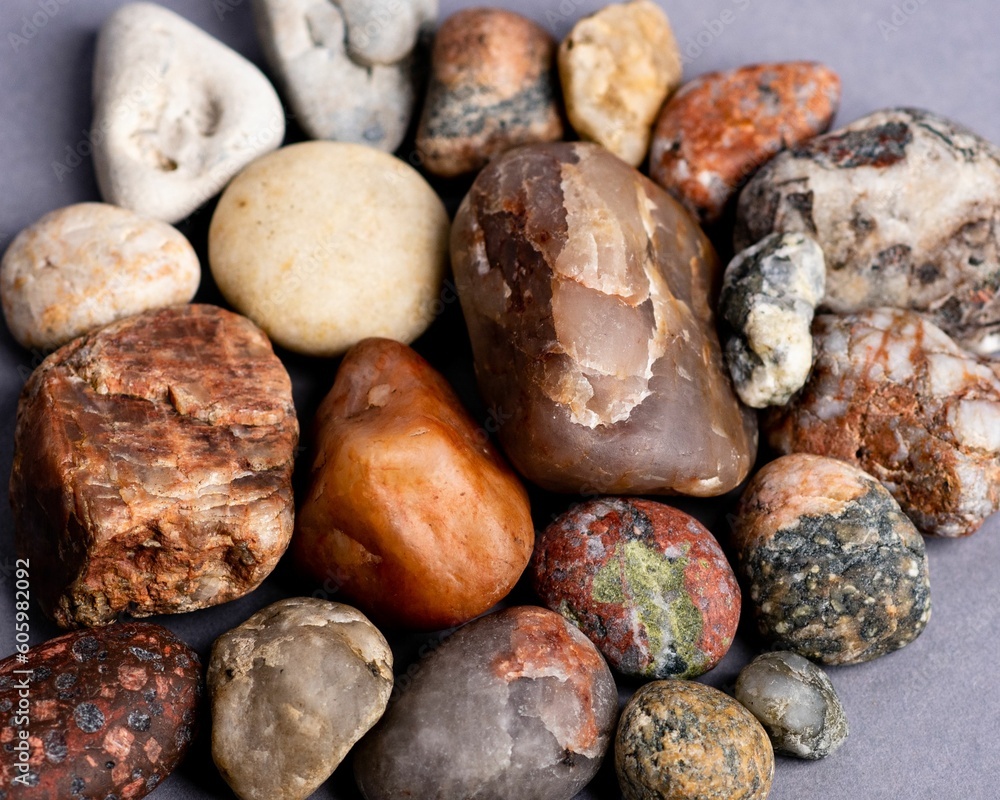 Close-up of the natural stones, placed by each other on a mauve purple background Close-up of the natural stones, placed by each other on a mauve purple background