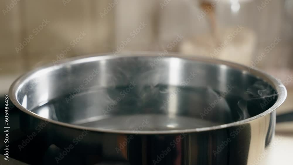 Closeup slow motion of steam from water in the steel pot, concept of food Closeup slow motion of steam from water in the steel pot, concept of food