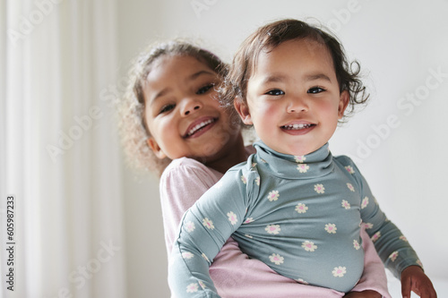 Schilderij op canvas Portrait, hug and a girl holding sister for love, care and bonding as siblings in a house