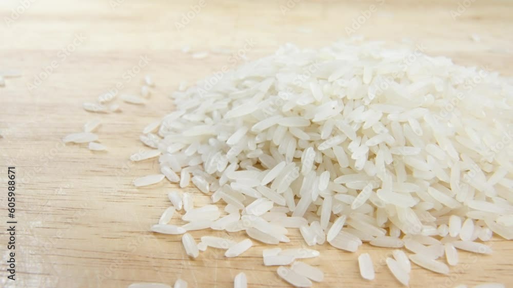 Close-up of a bunch of rice put on the wooden table surface on blurred background Close-up of a bunch of rice put on the wooden table surface on blurred background
