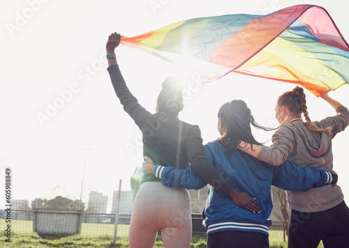Fitness, rainbow flag and female athletes outdoor for pride, health and wellness achievement. Sports, love and women friends embracing while walking for political homosexual equality and lgbtq rights