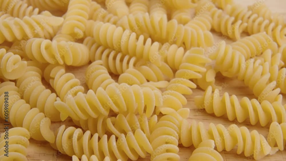 Closeup of a bunch of pasta put on the wooden kitchen board surface Closeup of a bunch of pasta put on the wooden kitchen board surface
