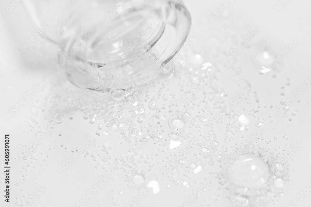 Transparent gel or liquid with bubbles flowing from the bottle onto the background Transparent gel or liquid with bubbles flowing from the bottle onto the background