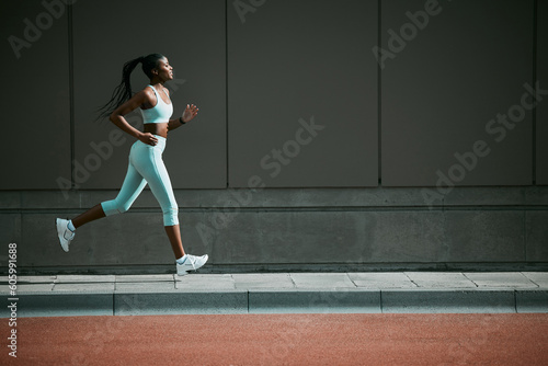 Black woman, running and city sidewalk with training, exercise and fitness on urban road. Street, runner profile and female athlete with mockup and body workout for health, wellness and race outdoor © Haas/peopleimages.com