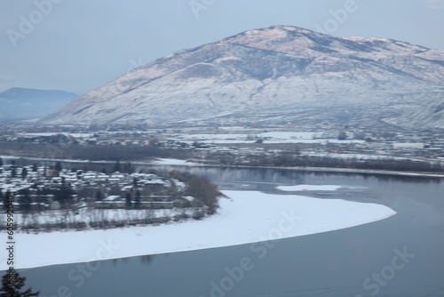 Aerial shot of frozen lake near snow covered mountain peaks