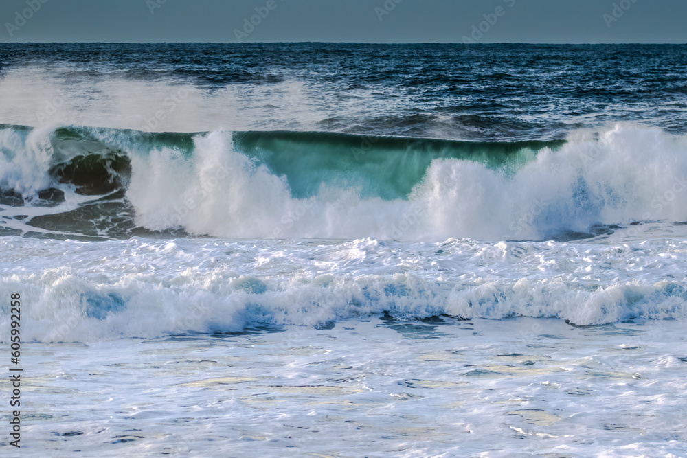 Obraz premium Sunrise and waves at the seaside