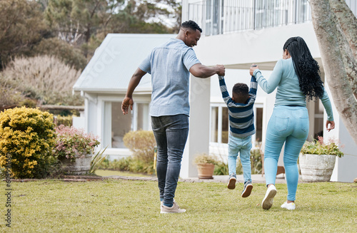 Mother and father lifting child by their new home in the outdoor garden while playing together. Backyard, bonding and back of African parents holding their boy kid in the backyard of their house.