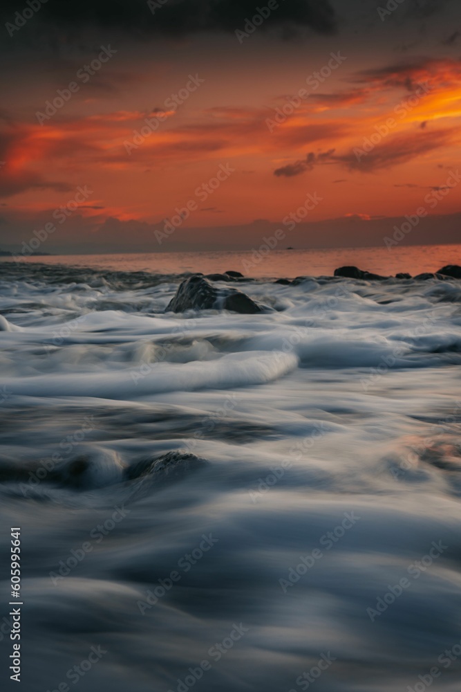 Obraz premium Long exposure of sea waves during sunset