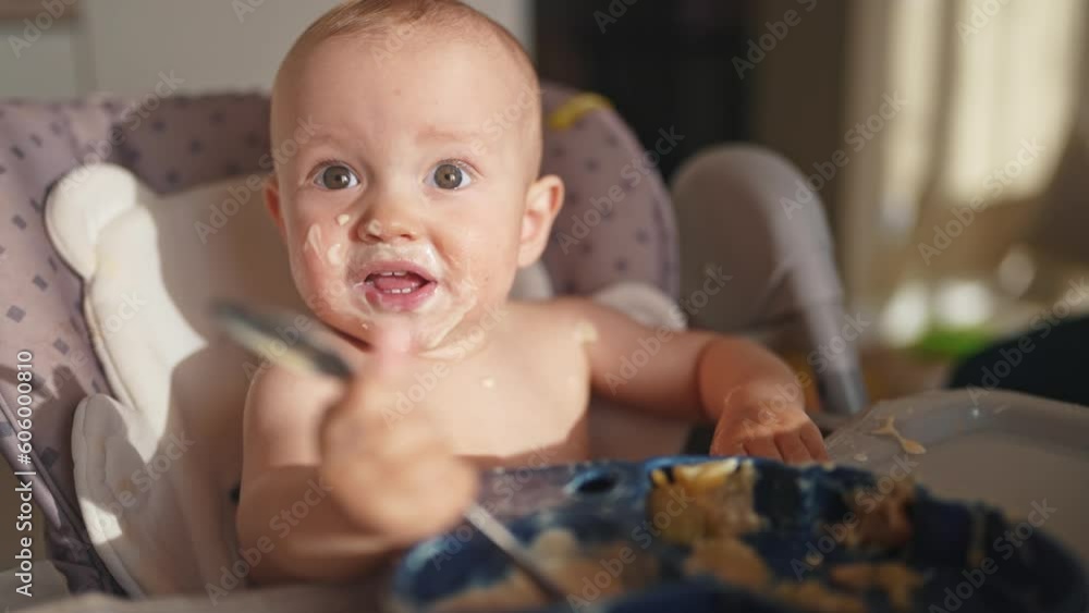 baby dirty eats. happy family a child toddler concept. baby dirty sitting messing with lifestyle food at the table for feeding in the kitchen. grimy toddler in the kitchen baby dirty eats. happy family a child toddler concept. baby dirty sitting messing with lifestyle food at the table for feeding in the kitchen. grimy toddler in the kitchen