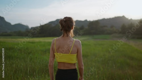 slow motion portrait of Young Athlete Woman enjoyinng beautiful green rural field landscape after running outdoors along Green Fields. photo