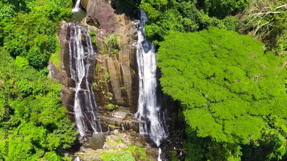 Jungle Waterfall in a tropical forest surrounded by green vegetation. Hunas Falls in mountain jungle. Hunnasgiriya, Sri Lanka. Jungle Waterfall in a tropical forest surrounded by green vegetation. Hunas Falls in mountain jungle. Hunnasgiriya, Sri Lanka.