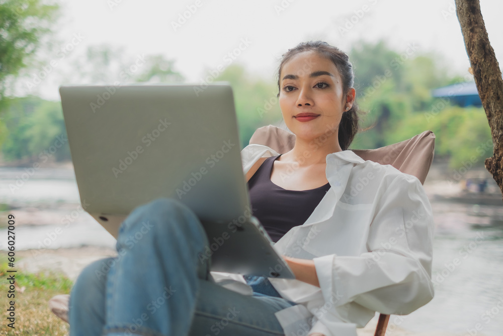 Close up of A professional businesswoman is working and looking at laptop while on vacation, trip or traveling. Concept working space outdoor. Wireless freedom work new normal lifestyle work. Close up of A professional businesswoman is working and looking at laptop while on vacation, trip or traveling. Concept working space outdoor. Wireless freedom work new normal lifestyle work.