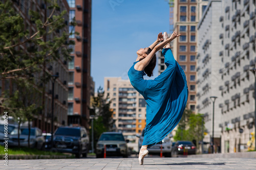 Print op canvas Beautiful Asian ballerina dancing outdoors. Urban landscape.