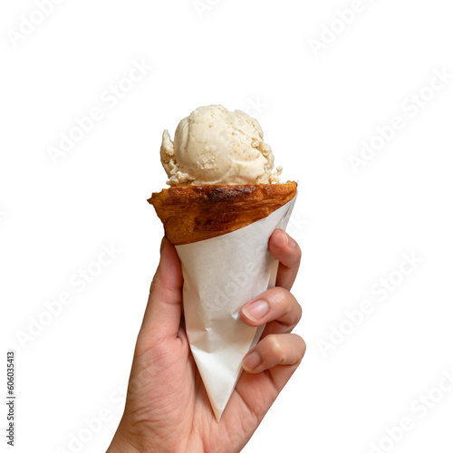 Hand holding scoop of sweet ice cream on croissant cone