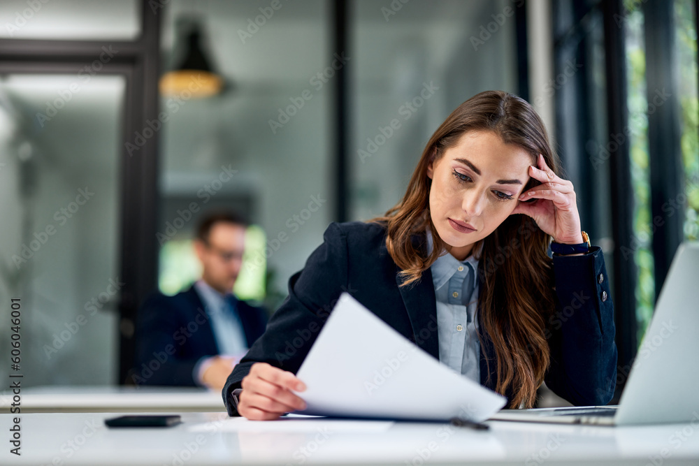 A pretty businesswoman analyzing business documents, sitting at the office. A pretty businesswoman analyzing business documents, sitting at the office.