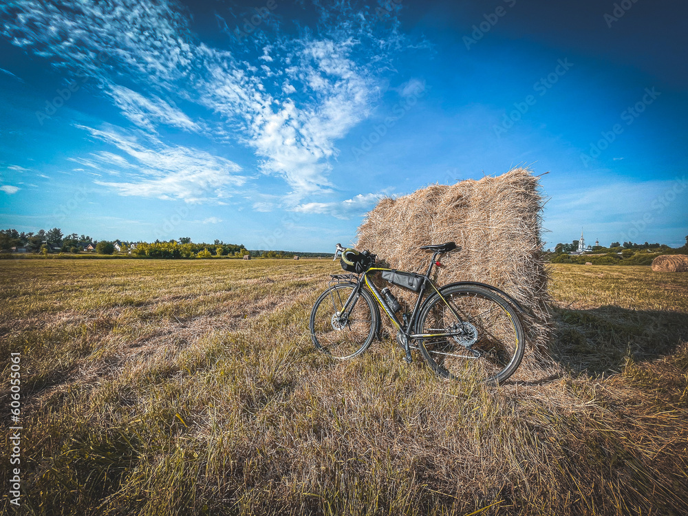 a bicycle in the countryside against a backdrop of a haystack, a touring bicycle a bicycle in the countryside against a backdrop of a haystack, a touring bicycle