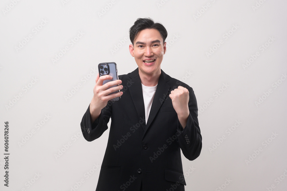 Asian Young businessman wearing suit using smartphone over white background studio Asian Young businessman wearing suit using smartphone over white background studio