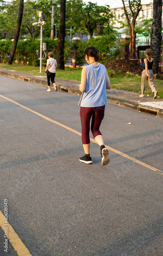 young asian woman jogging in the park at early morning.