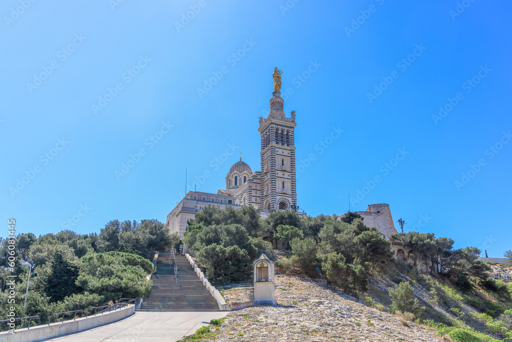 A scenics view of the Basilique Notre-Dame-de-la-Garde, la Bonne Mère,  Marseille, bouches-du-rhône, France under a majestic blue sky