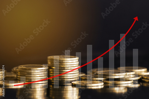 Stack of golden money coin with graph and red curve up arrow on black background. Business and financial concept. 