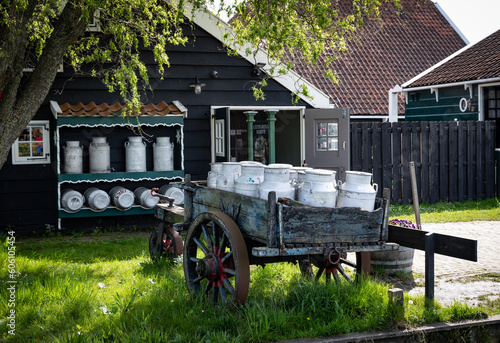 A cart with milk cans on the back of the cheese dairy