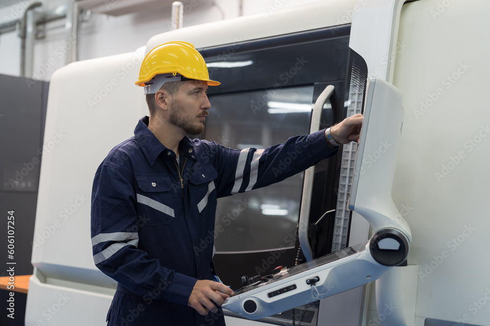 Male engineer worker working with CNC milling machine at production line in the industry factory. Male engineer worker control CNC machine tools for turning and milling in the factory Male engineer worker working with CNC milling machine at production line in the industry factory. Male engineer worker control CNC machine tools for turning and milling in the factory