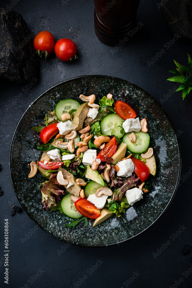 Fresh salad with Feta cheese, cucumbers, lettuce, cherry tomatoes, avocado, arugula and cashew nuts.