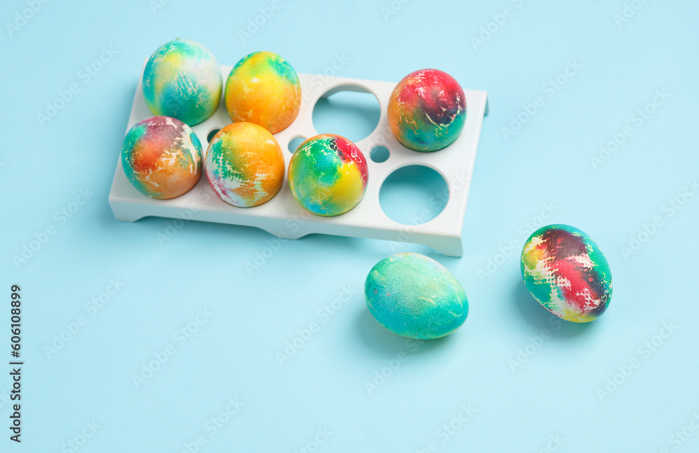 Colored Easter eggs in a tray, blue background Colored Easter eggs in a tray, blue background