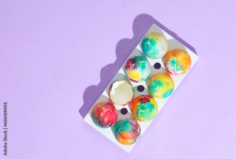 Colored Easter eggs in tray on purple background with shadow. Creative layout Colored Easter eggs in tray on purple background with shadow. Creative layout