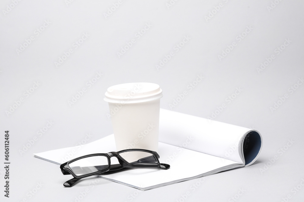 Conceptual business photo. Empty open white notebook, eyeglasses and a coffee cup on gray background. Template for design, mockup Conceptual business photo. Empty open white notebook, eyeglasses and a coffee cup on gray background. Template for design, mockup