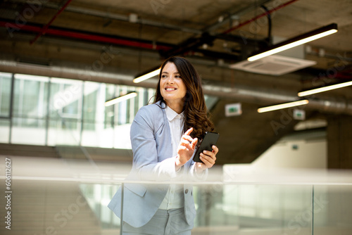Young business woman using mobile phone in the office hallway Free Download Young business woman using mobile phone in the office hallway - GFXLoad
