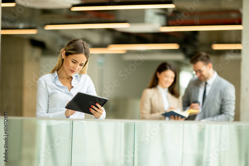 Young business woman with digital tablet in the office hallway © BGStock72