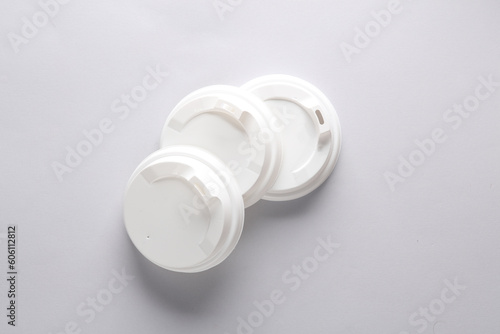 White plastic disposable lids for cup on gray background. Mockup, template for design
