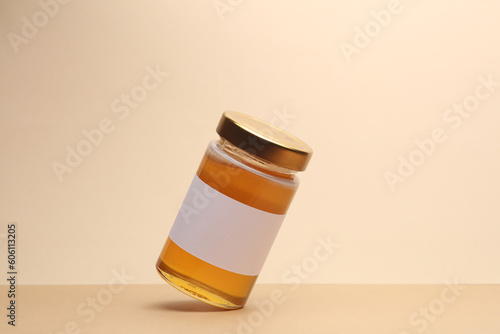 Glass Honey jar levitation on a two-tone beige background