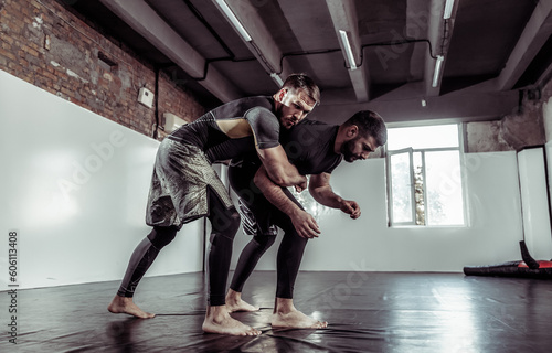 Fotografie Sparring training of two athletic mma fighters in the gym