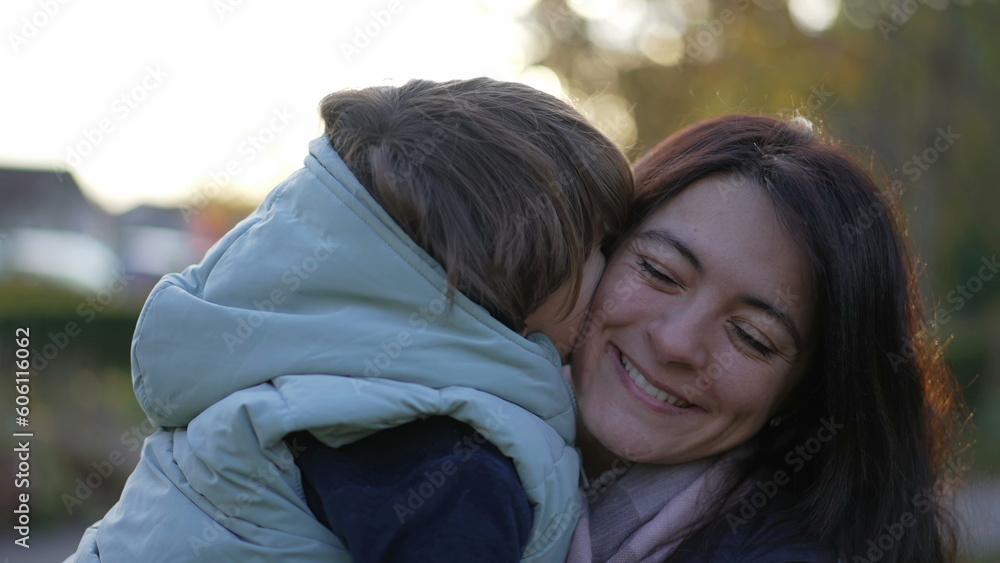 Fototapeta premium Happy mother and child relationship. Small son kissing mom in cheek. Real life moterhood lifestyle. loving caring parenting motherhood lifestyle