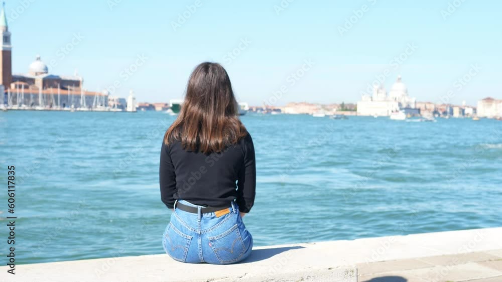 Female tourist looks at the fascinating view of the sea and the city life of the city on the water. Female tourist looks at the fascinating view of the sea and the city life of the city on the water.