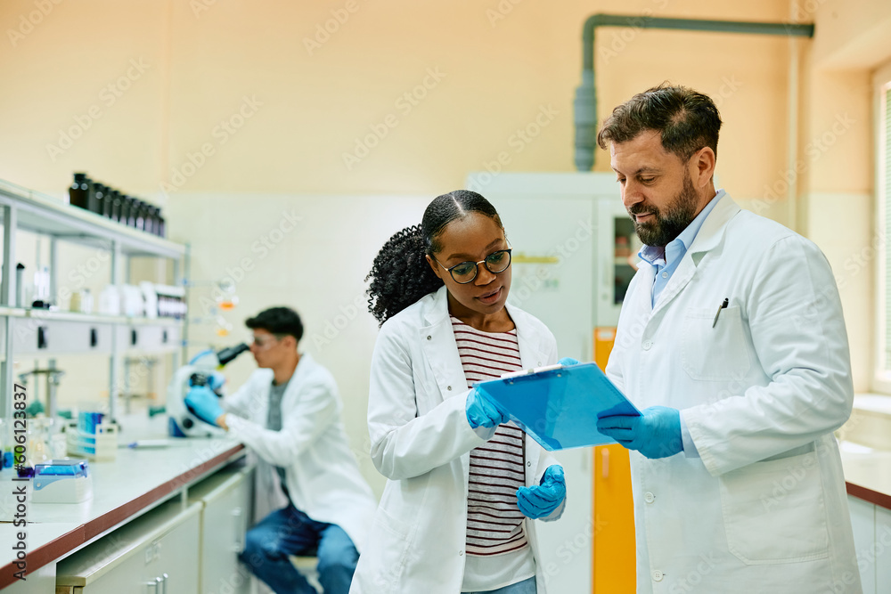 Fototapeta premium Two scientist analyzing research data while working in laboratory.