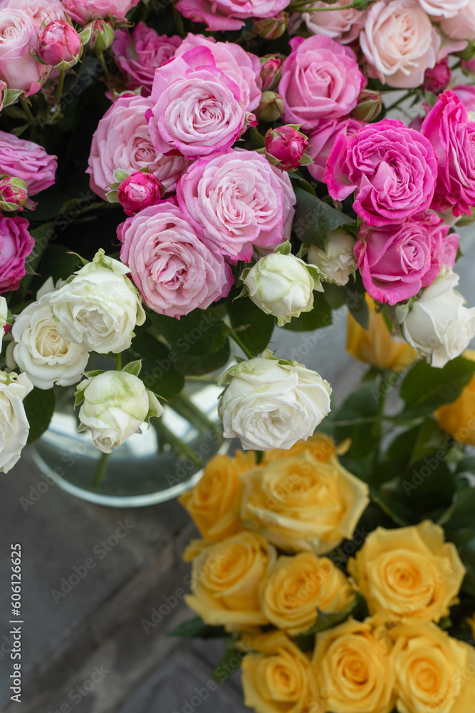 Flowers in a glass vase on the steps of a flower shop. Fresh peony and yellow roses outside. Master classes and floristry courses. Flower delivery. Flowers in a glass vase on the steps of a flower shop. Fresh peony and yellow roses outside. Master classes and floristry courses. Flower delivery.