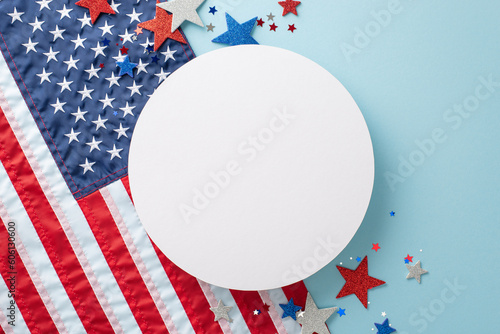 USA-themed party decorations: Top view showcasing symbolic elements like shimmering stars, confetti, and national flag. Pastel blue backdrop with a vacant circle for text or advertisement