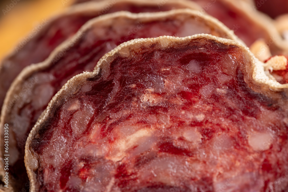 Obraz premium Sausage cut into pieces on the table