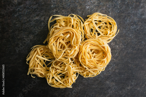 Tagliatelle Pasta Nests Stacked and Viewed from Above: Nests of dried pasta noodles piled into a group and viewed from directly above