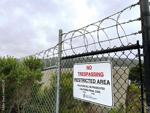 No Trespassing Sign With Barbed Wire Fence and Gate at Crystal Springs Water Reservoir of Hetch Hetchy System in San Mateo County, San Francisco Bay Area, California near San Andreas Fault photo