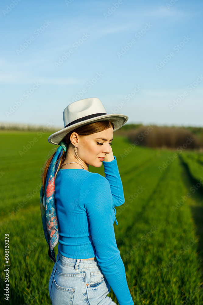 A cute woman in jeans and a hat stands in a green field. A smiling woman in a blue top and jeans walks in the green grass. A cute woman in jeans and a hat stands in a green field. A smiling woman in a blue top and jeans walks in the green grass.