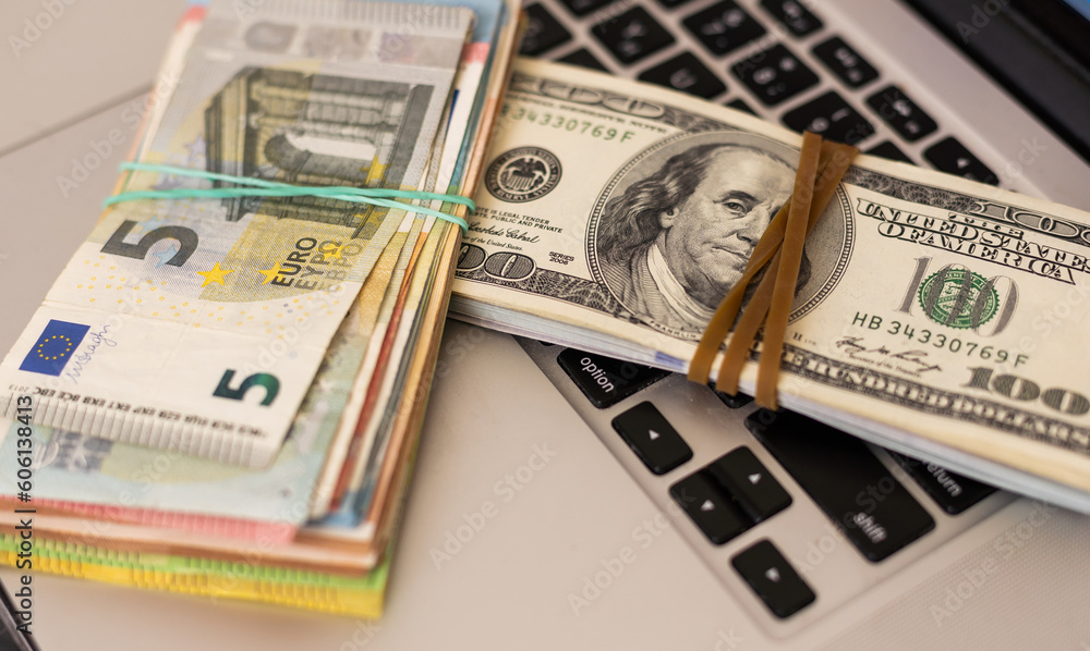 Pile of euro money with Laptop on the table Pile of euro money with Laptop on the table