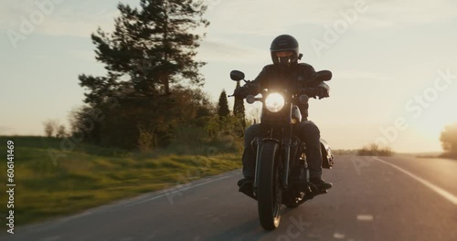 Slow-motion shot of a male driving a motorcycle through an empty road.